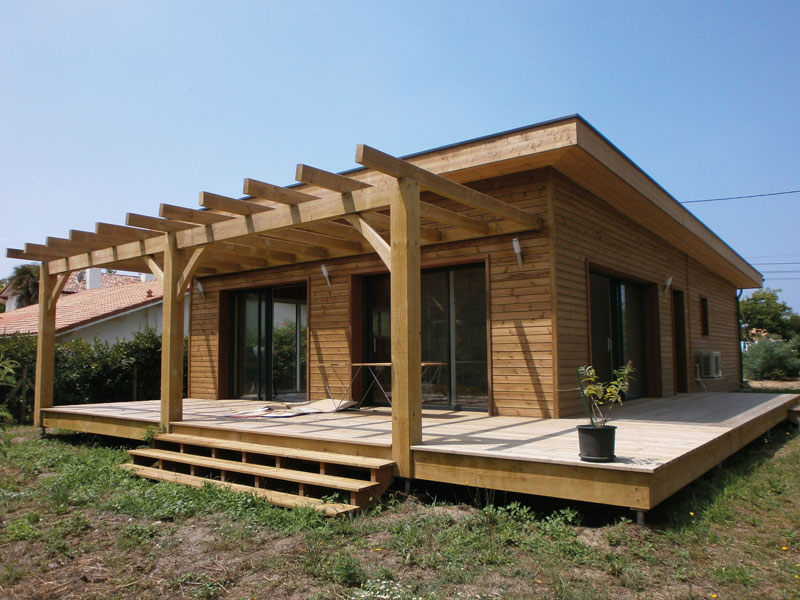 Maison en bois avec grande terrasse couverte